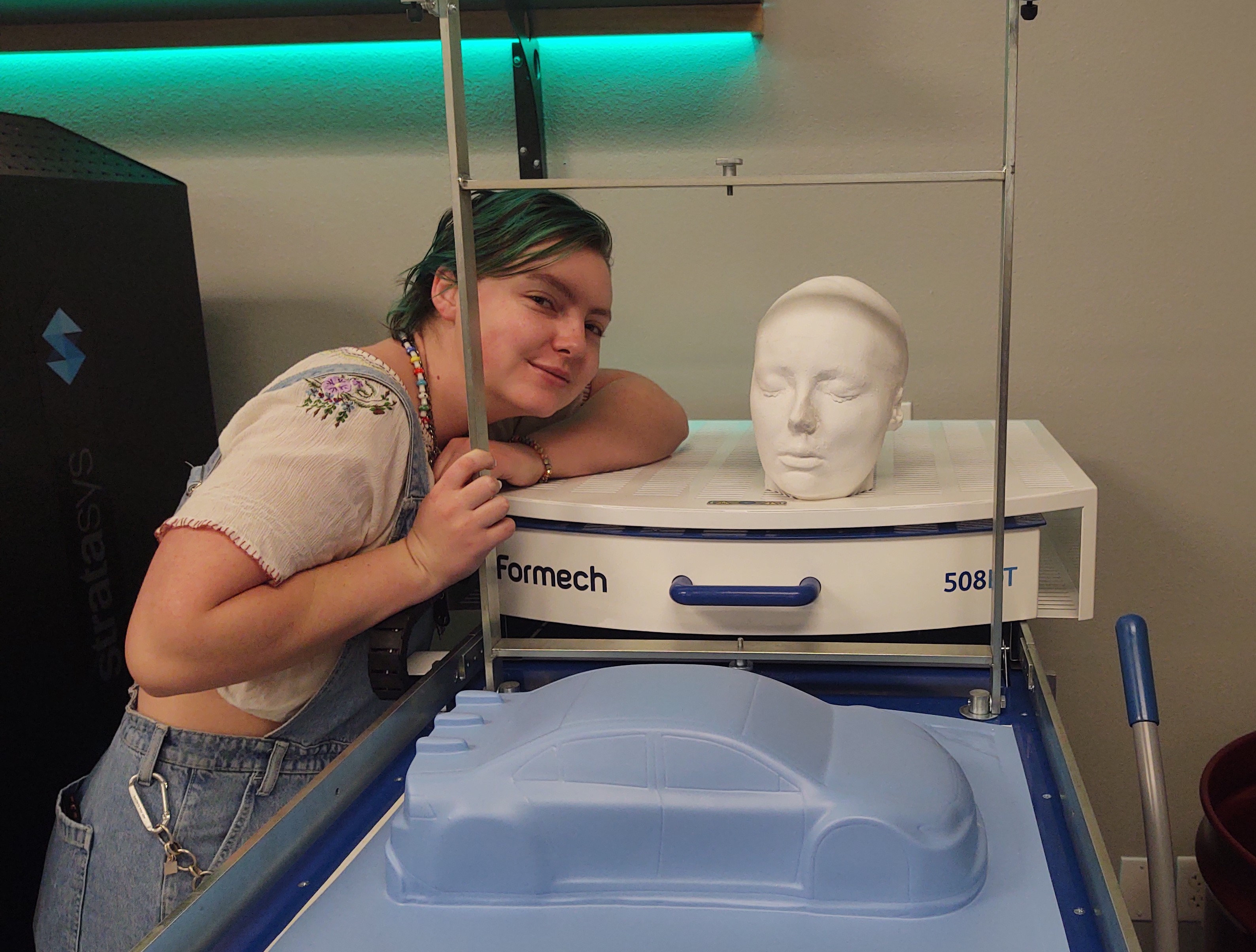 Carly next to plaster head on a vacumform